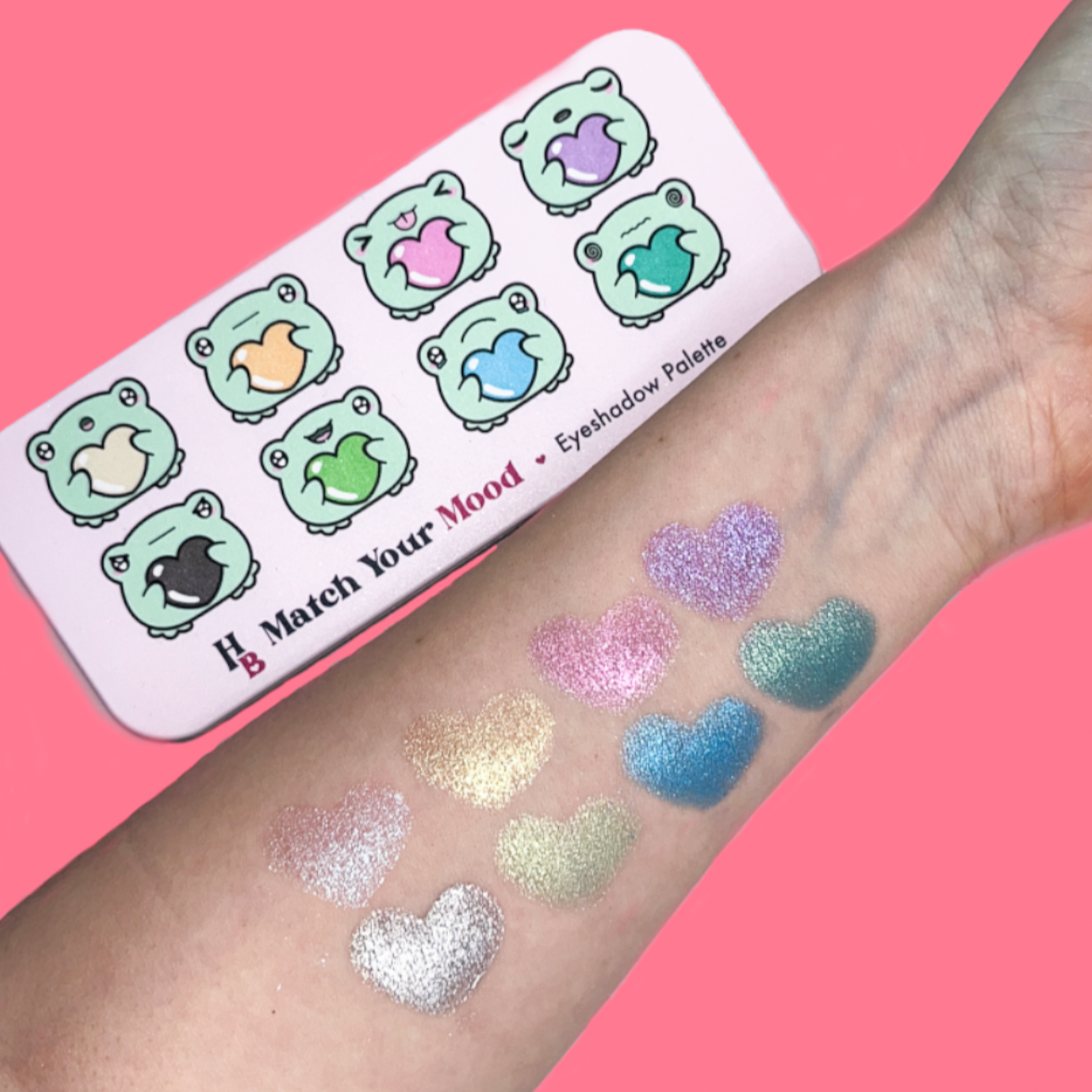 The Match Your Mood reflective shadows, swatched in the shape of hearts on a light skin arm, the shadows are shimmery and reflect the light