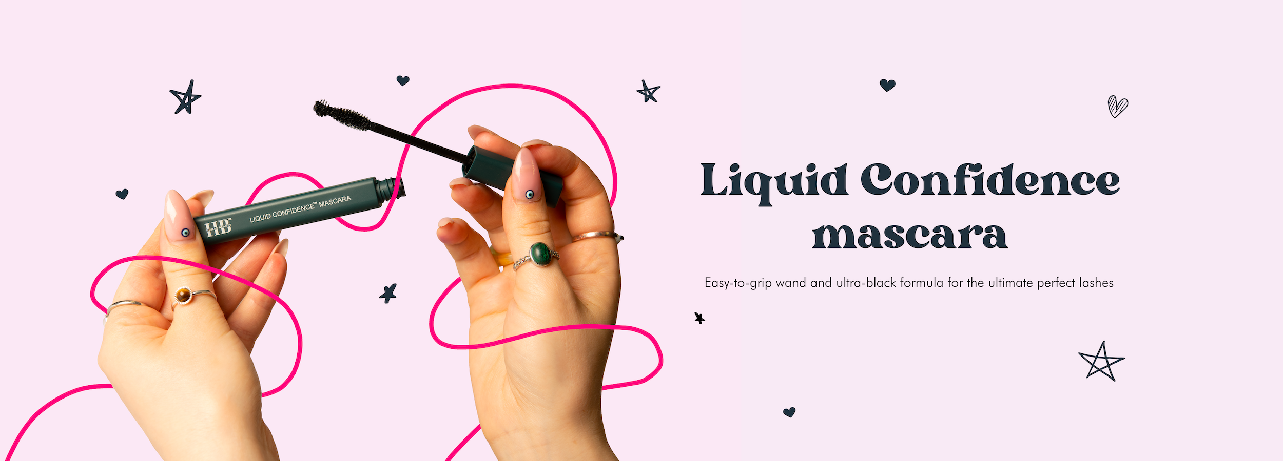 Large visual of the Liquid Confidence mascara being held open by two hands on a light purple background. A text reads "Liquid Confidence Mascara. Easy-to-grip wand and ultra-black formula for the ultimate perfect lashes".