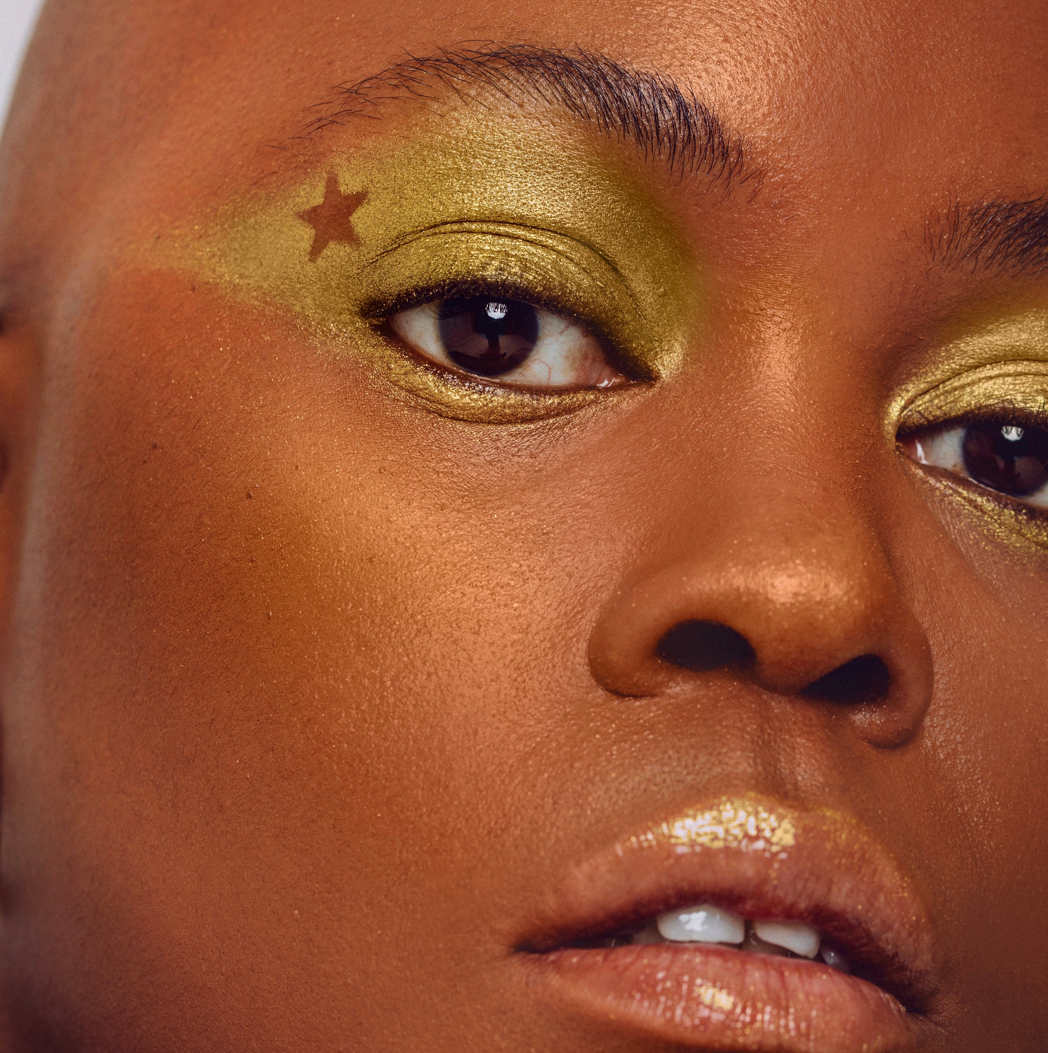 A gold eye makeup look with a star shape cut out using shade Expression from the Makeup Therapy Palette.